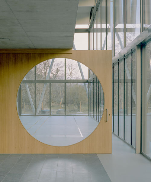 lattice of beams enfolds multipurpose gymnasium's facade in switzerland by demattè fontana